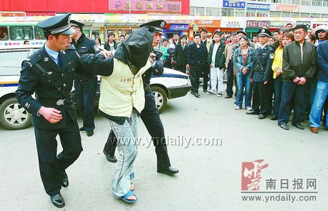 押歹徒指认现场江洋摄本报讯 看着两个被抓获的嫌疑人指认现场,围观