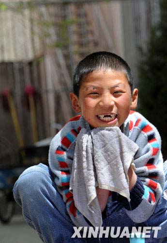 4月13日,面带微笑的小学生夏加在室外洗脸.新华社记者 觉果 摄