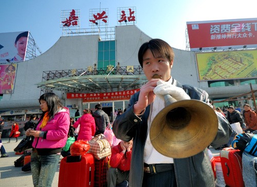 在嘉兴市火车站,来自湖南省吉首市的苗族青年龙林海揣着伴随自己多