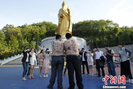 2名赤膊男子景區內背部互寫在此一遊(圖)