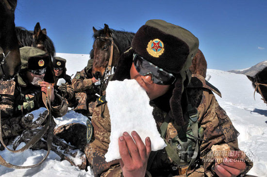 資料圖:解放軍駐守高原軍人巡邏途中就雪吃乾糧