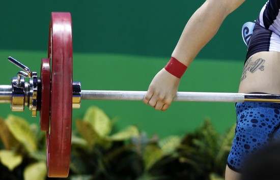 她右腿侧面的小杠铃纹身和比赛中的大杠铃相映成趣.